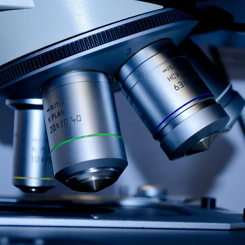 Microscópio de laboratório avaliado sob os protocolos de segurança e gestão de riscos hospitalares.